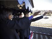 Barack Obama s manelkou mávají lidem kolem trati.