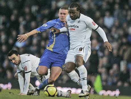 Portsmouth - Swansea, domácí Martin Cranie ( v modrém) bojuje s Jasonem Scotlandem.