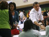Barack Obama s manelkou Michelle vítají dobrovolníky, kteí pili do koly Calvin Coolidge High School ve Washingtonu pomáhat s dobrovolnickými pracemi (19. leden 2009)