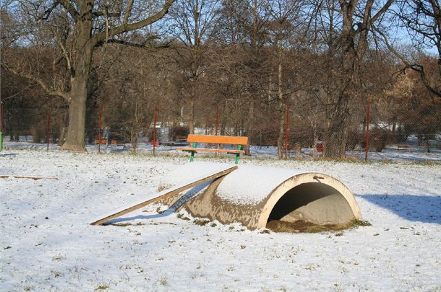I na psím hřišti se najdou prolézačky. (V pozadí dětské hřiště a park Podvinní, Praha 9.)