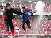 Fotbalisté 1. FC Brno uklízí sníh ze sedaek stadionu na Srbské