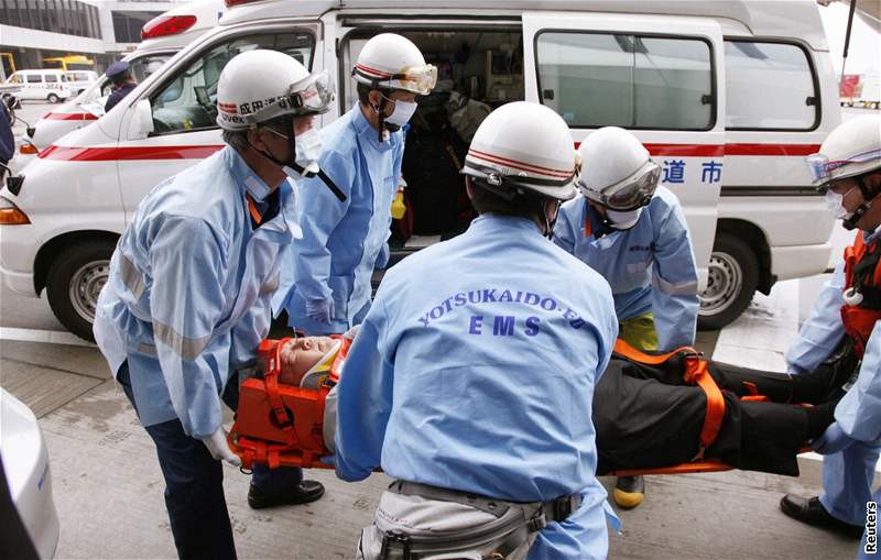 Záchranái penáejí na tokijském letiti pasaéra letadla Northwest Airlines, který se zranil pi turbulencích. (20. únor 2009)