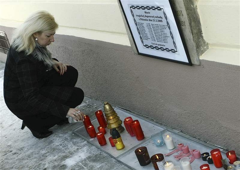 ena zapaluje svíku ped Mstským úadem v Bánovcích nad Bebravou, kam lidé 22. února picházeli uctít památku obtí tragické nehody, pi ní zemelo 12 lidí z Bánovc a okolí.