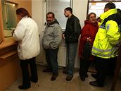 Mstský policista asistuje pi vyplácení sociálních dávek na chomutovském mstském úad (23. února 2009)