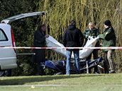 Policisté odná�ejí t�lo zabitého �lov�ka poblí� �koly Albertville, kde zabíjel �ílený st�elec. (11. b�ezen 2009)