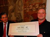 Úsp�ný �eský paralympionik Roman Musil (vpravo) p�ebírá pro spastiky od pra�ského radního Petra Hulínského p�lmilionový �ek