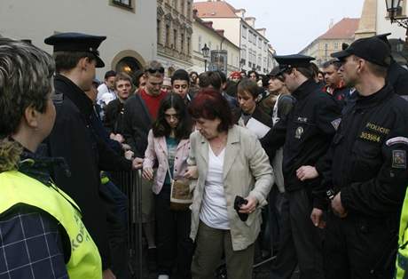 Policisté dav postupn po prohlídkách pomocí bezpenostních rám poutí pes zábrany (5. dubna 2009)