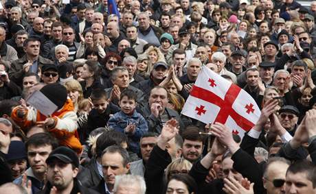 Nad hlavami demonstrant v Gruzii je gruzínská vlajka s erveným svatojiským kíem