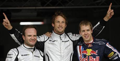 Jenson Button (uprostrd) z Británie, vlevo jeho týmový kolega Rubens Barrichello a Sebastian Vettel z Nmecka.