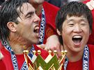 Carlos Tevez (vlevo) a Park Ji-Sung slaví titul v Premier League s Manchesterem United