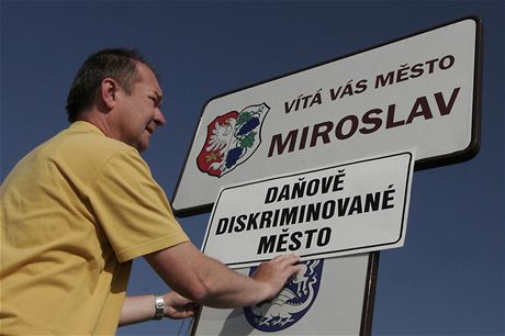 Místostarosta Miroslavi Roman Volf p�ipev�uje na vjezdu do obce ceduli "Da�ov� diskriminované m�sto" b�hem protestu malých obcí (26. kv�tna 2009)