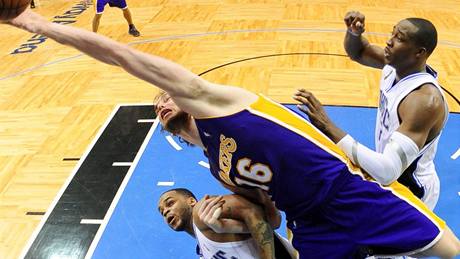 Orlando - LA Lakers, hostující  Paul Gasol se natahuje po míi. Brání ho Jameer Nelson (vlevo) a Dwight Howard.