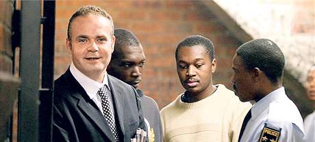 Jihoafrický policista odvádí eského podnikatele Radovana Krejíe k soudu v Kempton Parku. (3. kvtna 2007)