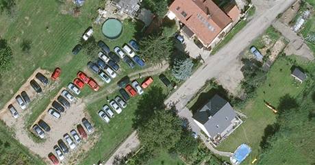 Letecký snímek Přední Kopaniny, na kterém je vidět soukromé parkoviště mezi domy.