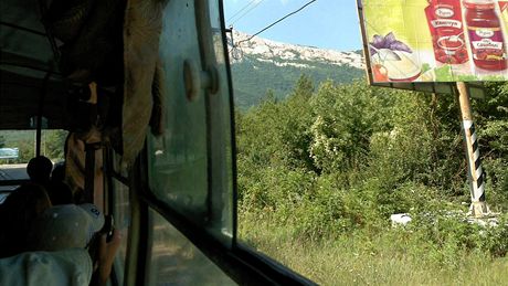 Trolejbus do prímoské Aluty se kodrcá pod strmými skalnatými horami.