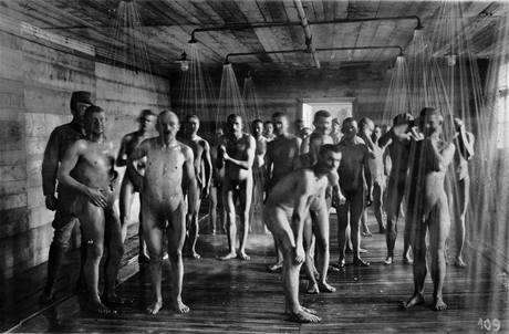 Italští zajatci, kteří byli předtím odvšiveni, se sprchují pod dohledem rakousko-uherské stráže.