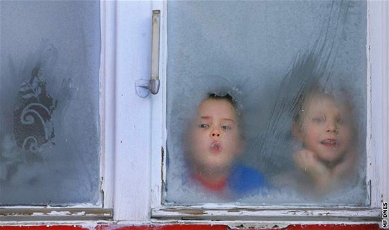 Dti z mateské kolky ve Velkých Petrovicích dýchají na namrzlé sklo okna. Ilustraní fotoI