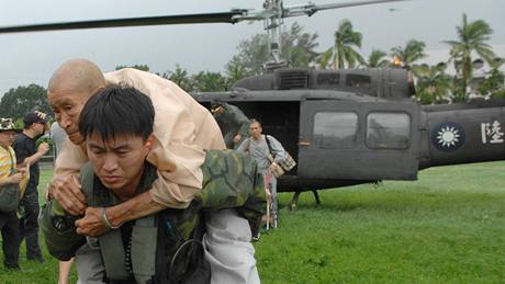 Voják nese mue, který peil sesuv pdy v tchajwanské vesnici ao Lin zpsobený tajfunem Morakot (10. 8. 2009)