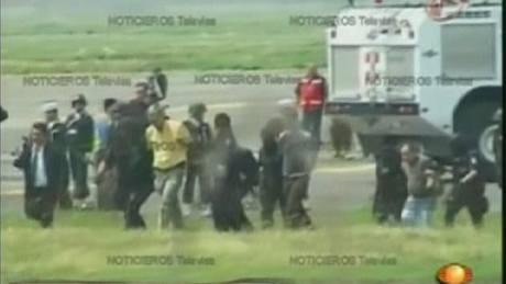 Policie odvádí únosce mexického letadla. (9. záí 2009)