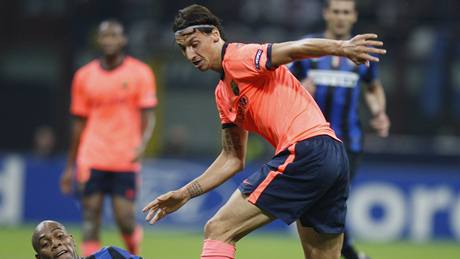 Inter Milán - Barcelona, s míem kouzlí hostující Ibrahimovi, zastavuje ho domácí Maicon (na zemi).