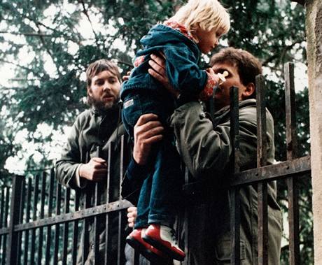 Neboj se, bude to dobr. Uprchlci pobvajc ji na zahrad ambasdy SRN pebraj dt, jeho matka je jet mimo zem velvyslanectv, Praha 3. jna 1989.