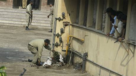 len pákistánských bezpenostních sloek odebírá zastelenému ozbrojenci sebevraednou vestu s výbuninou. (15. íjna 2009)