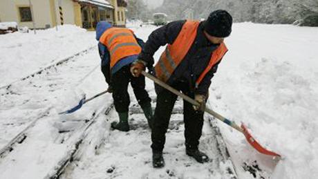 Pracovnci soukrom eleznice Desn odklzej snh mezi kolejemi na ndra v Koutech nad Desnou na umpersku. (16. jna 2009)