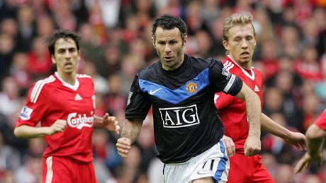 Liverpool - Manchester United: hostující Ryan Giggs (v erném) v obklíení domácích