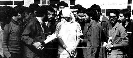 Írántí studenti, kteí zajali pracovníky americké ambasády v Teheránu v roce 1979 s jedním ze zadrených Amerian.