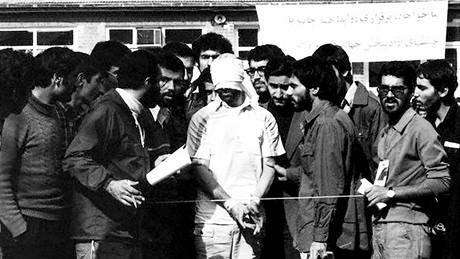 Írántí studenti, kteí zajali pracovníky americké ambasády v Teheránu v roce 1979 s jedním ze zadrených Amerian.