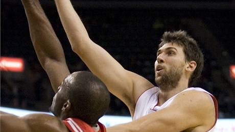 Toronto - Houston: torontský Andrea Bargnani (v bílém) zakonuje pes Carla Landryho