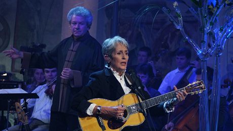 Americkou písnikáku a politickou aktivistku Joan Baez na koncert doprovázela Praská komorní filharmonie pod vedením Jiího Blohlávka (v pozadí).