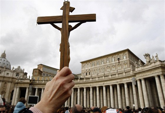 Muž zdvihá kříž na náměstí Svatého Petra v Římě