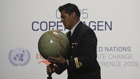 Jeden z organizátor nese globus na pódium konference v Kodani