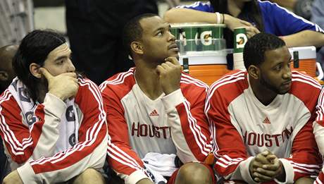 Tracy McGrady (vpravo) sedí na lavice Houstonu Rockets. Vlevo Luis Scola, uprosted Chuck Hayes.