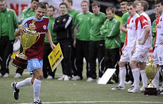 Martin Dobrotka ze Slovanu Bratislava si odnáí pohár pro vítze turnaje po finálovém utkání proti Slavii. Pihlíejí hrái Slavie (vpravo) a tvrtého týmu v celkovém poadí Bohemians 1905.