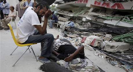 Haian sed u zrann eny a ek s n na zdravotn pomoc. Lkai v Port-au-Prince nesthaj oetovat vechny zrann, ztily se i nemocnice (14. ledna 2010)