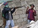 Maskovaný policista zadrel mladíka rabujícího v poboeném obchod v Port-au-Prince. (19. ledna 2010)