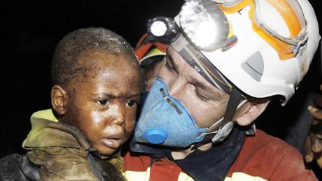 panlský záchraná nese malého chlapce, kterého vytáhli ivého z trosek poboeného domu. (15. ledna 2010)
