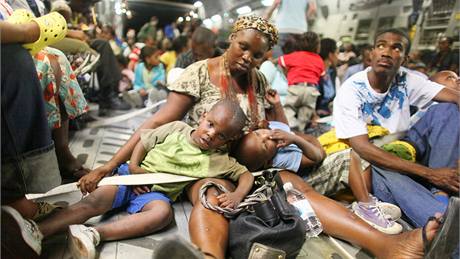 Tém�� 200 obyvatel Port-au-Prince sedí v dopravním letadle americké armády a mí�í na leti�t� v Orlandu v USA. (18. ledna 2010)