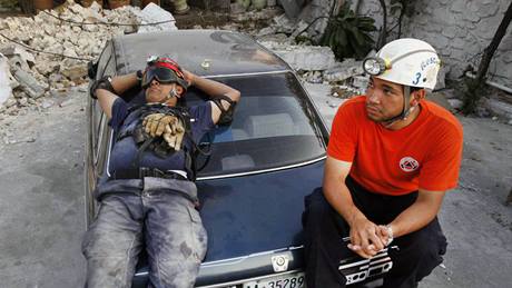 Záchrannái z Dominikánské republiky odpoívají mezi troskami dom v Port-au-Prince. (19. ledna 2010)