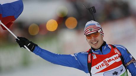 Ruský biatlonista Jevgenij Usťugov drží v ruce vlajku a spokojeně se usmívá. I díky němu ruská štafeta vyhrála závod v Ruhpoldingu.