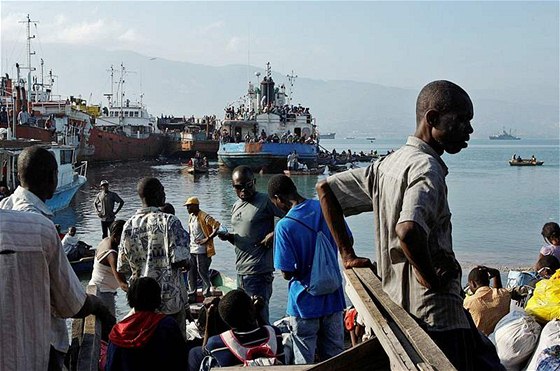 Haiané ekají v pístavu na lo, která je odveze z Port-au-Prince. (21. ledna 2010)