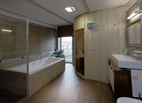 Rodinn koupelna svestavnou saunou je osvtlena velkm francouzskm oknem a funguje pro celou rodinu jako dal obytn mstnost