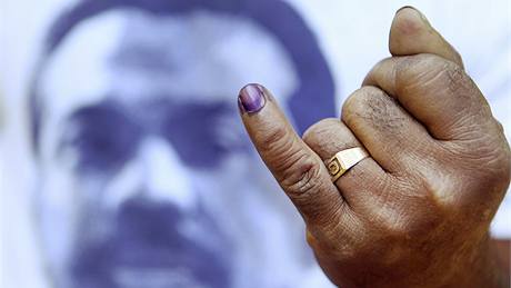 Po odevzdání volebního hlasu obarví voliovi prst nesmazatelným inkoustem. V pozadí je portrét prezidentského kandidáta Mahindy Radapakseho. (26. ledna 2010)