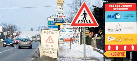 Na silnici II/610 v Brandýse nad Labem nkteré z reklamních cedulí zakrývají dopravní znaky.