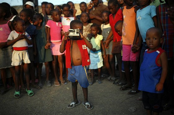 Haitský chlapec fotí v provizorním táboře pro přeživší v Port-au-Prince
