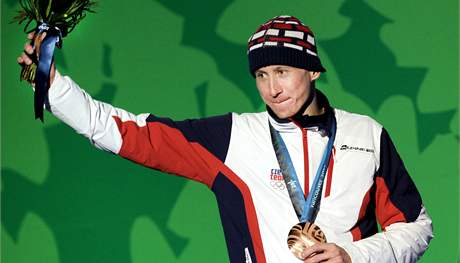 Luká Bauer stojí na stupních vítz s bronzovou medailí po závod na 15 km...