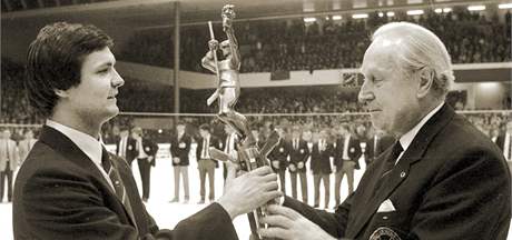 Pedseda IIHF Gnter Sabetzki (vpravo) pedv eskoslovenskmu kapitnovi Driu Rusnkovi trofej mistr svta. (1985)