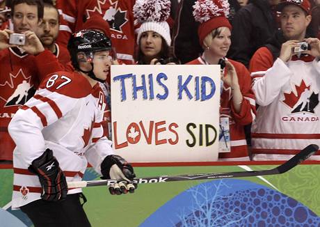 SID. Kanaan Sidney Crosby ped zpasem se vcarskem. V pozad transparent: "Tohle dt miluje Sida."
